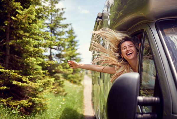 See the Country in an Rv but First Make Sure You Are Covered! - Blonde Woman on the Window of an Rv With Hands Out Smiling Enjoying Ride. Vacation Time